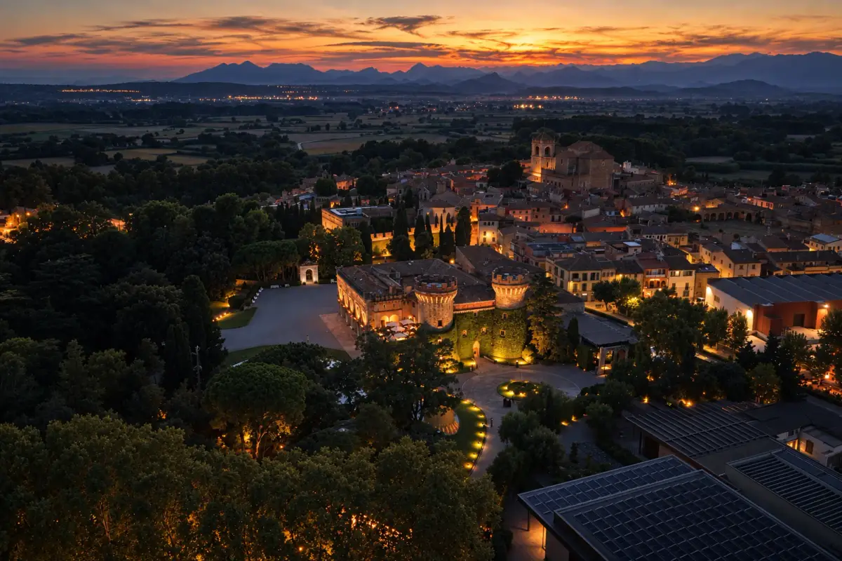Castillo y pueblo iluminados al anochecer vistos desde un dron