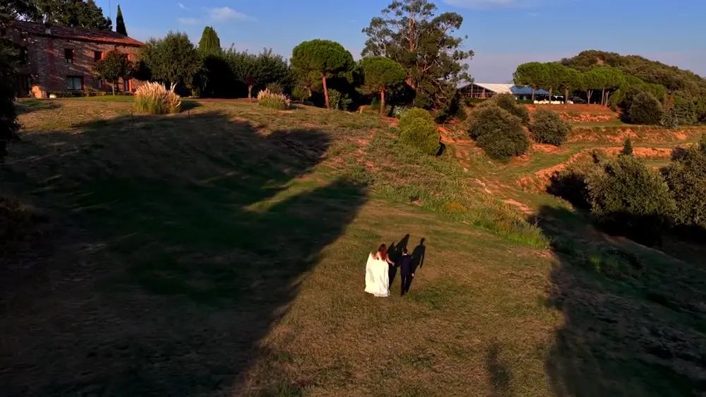 Novios paseando por una finca al atardecer, vistos desde un dron