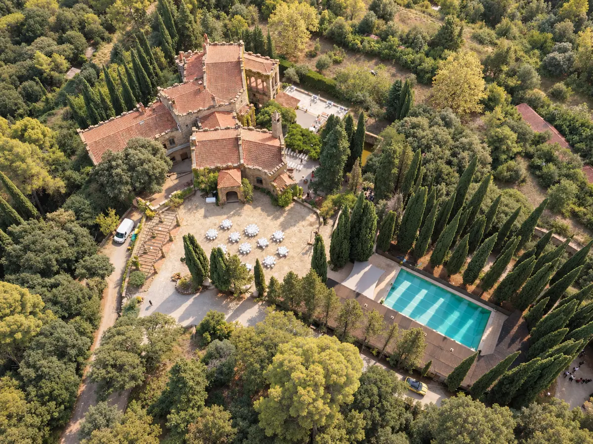 Masía con piscina rodeada de bosque vista desde un dron