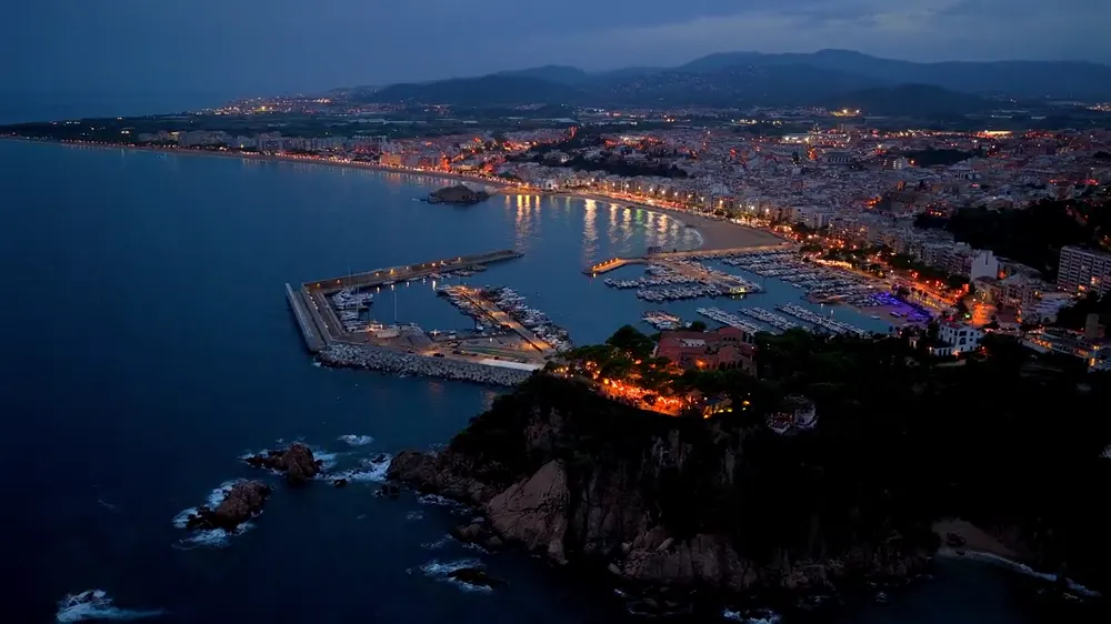 Vista aérea de una costa y su puerto al anochecer