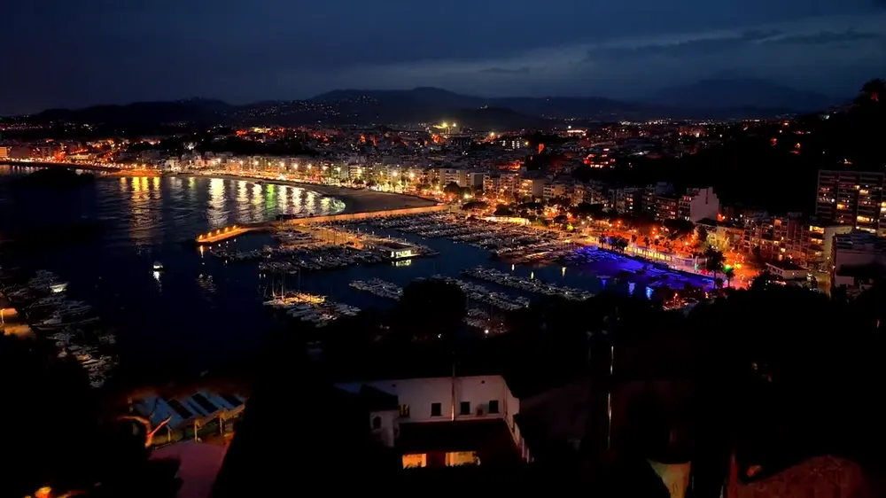 Vista aérea de una ciudad costera iluminada de noche