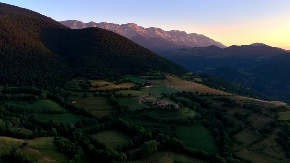 Vista aérea de montañas y valle al atardecer