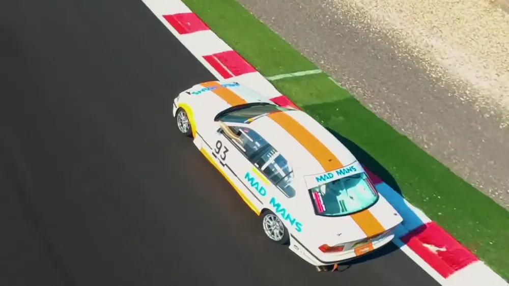 Coche de carreras en un circuito visto desde un dron