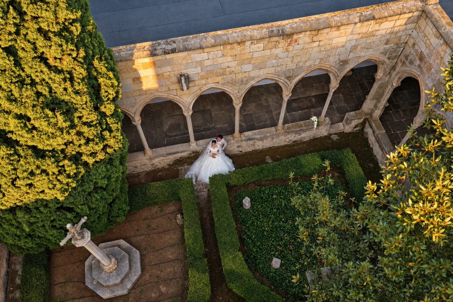 Pareja de novios en un claustro histórico vista desde arriba